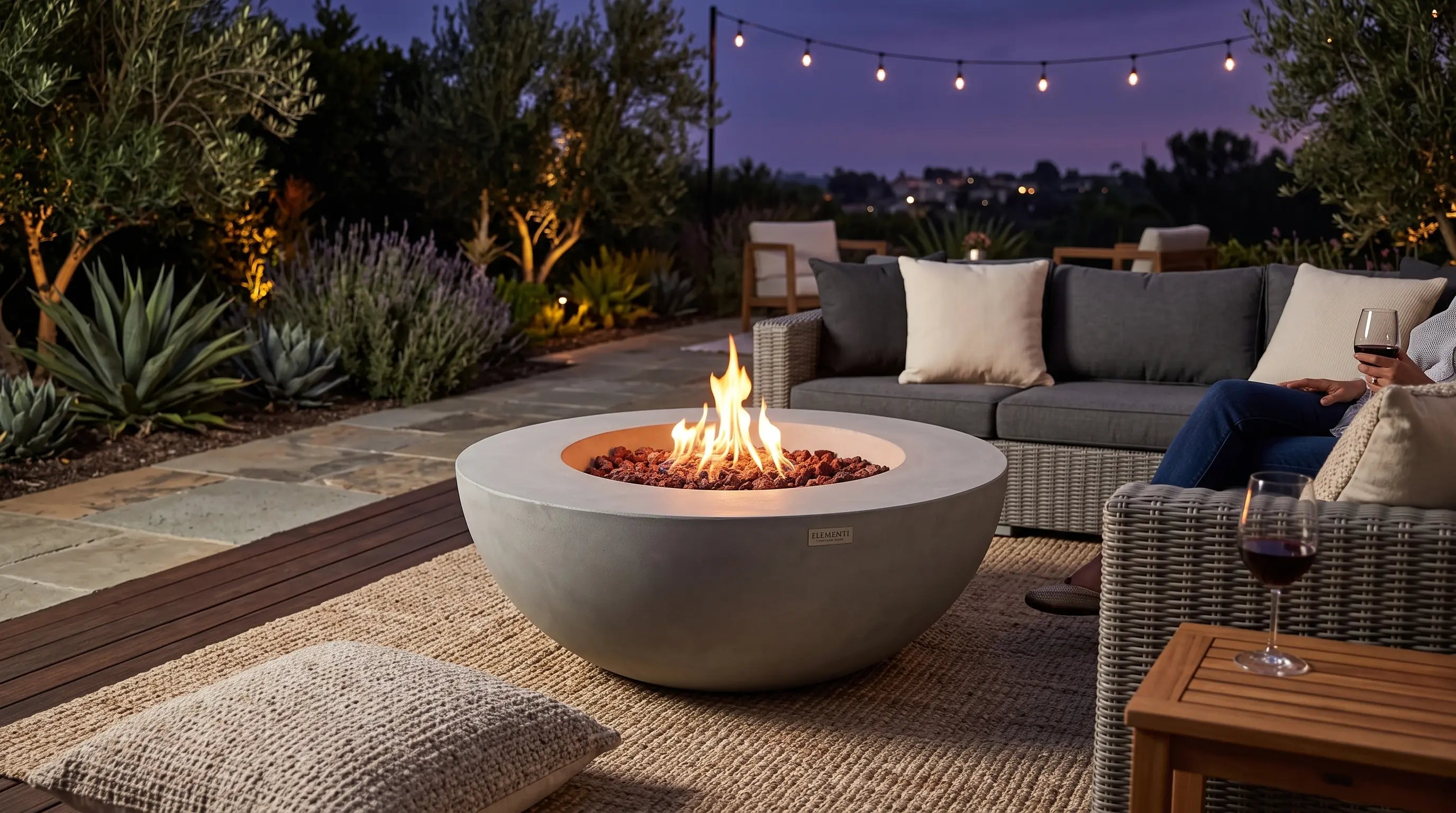 Round gas fire bowl as the glowing centerpiece of an outdoor lounge