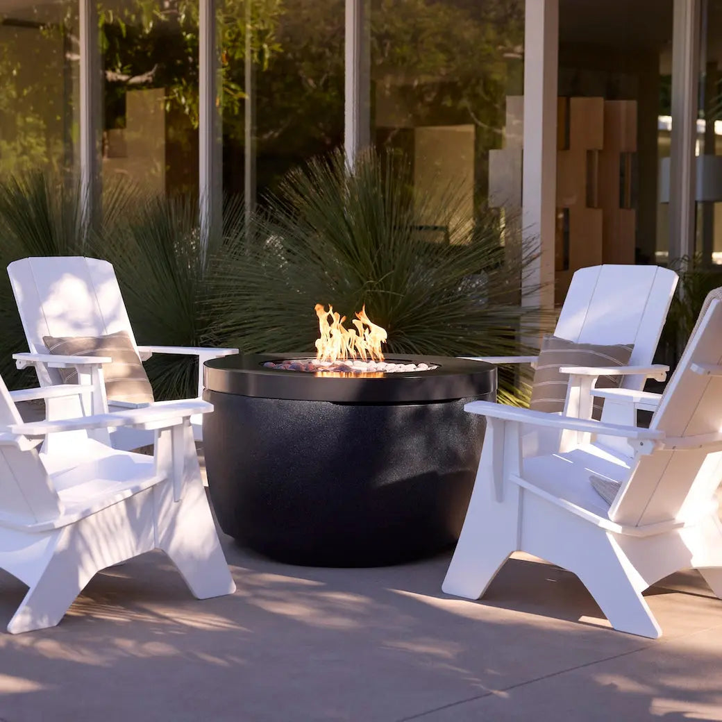 Ledge Lounger Halo propane fire pit lit at dusk