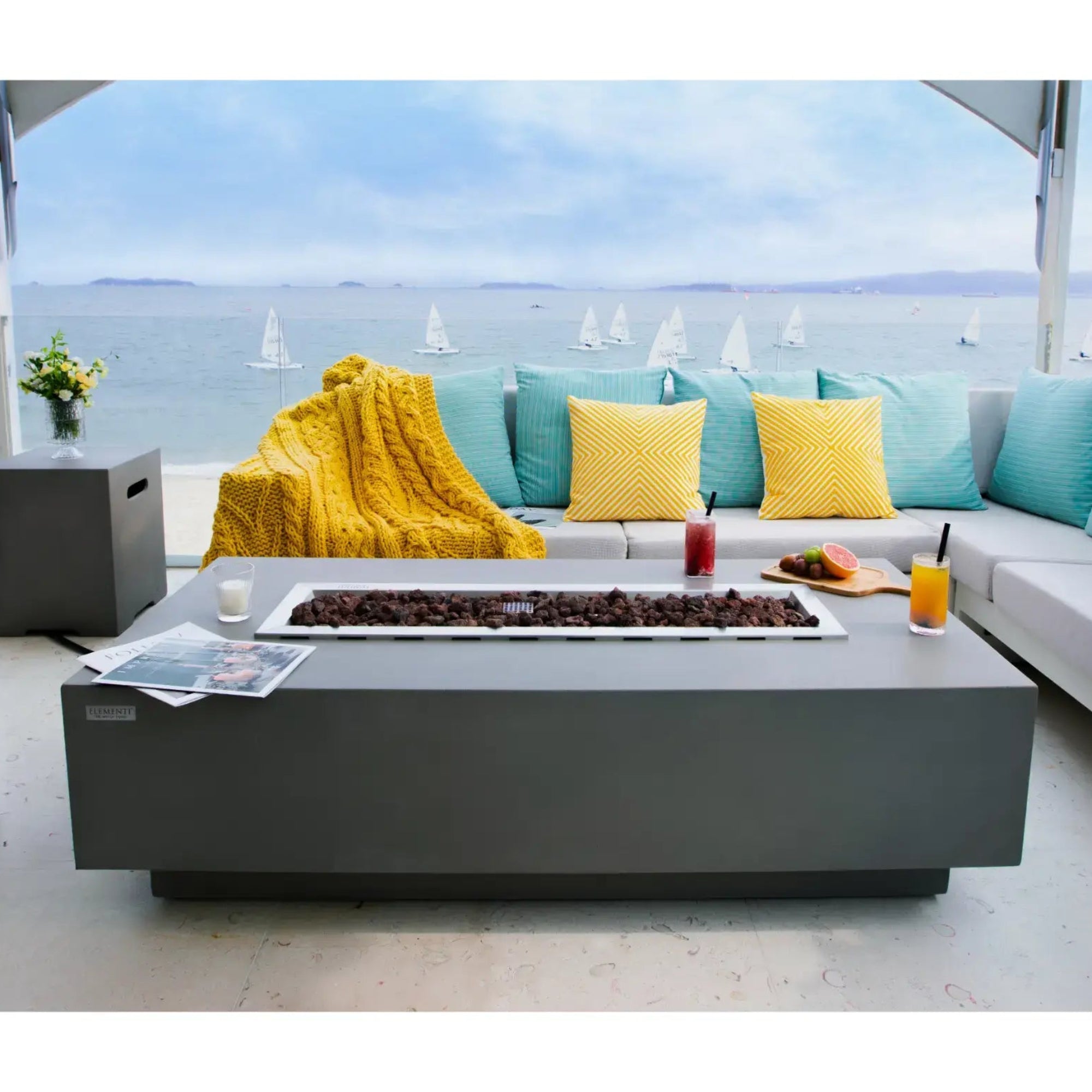 Outdoor patio set with fire pit table and sectional sofa by the sea