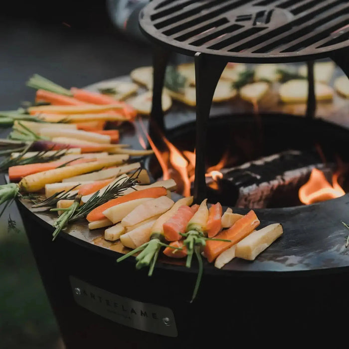 Arteflame flat top grill cooking a steak with smoky flavor — premium circular flat top grill with carbon steel cooking surface for outdoor cooking